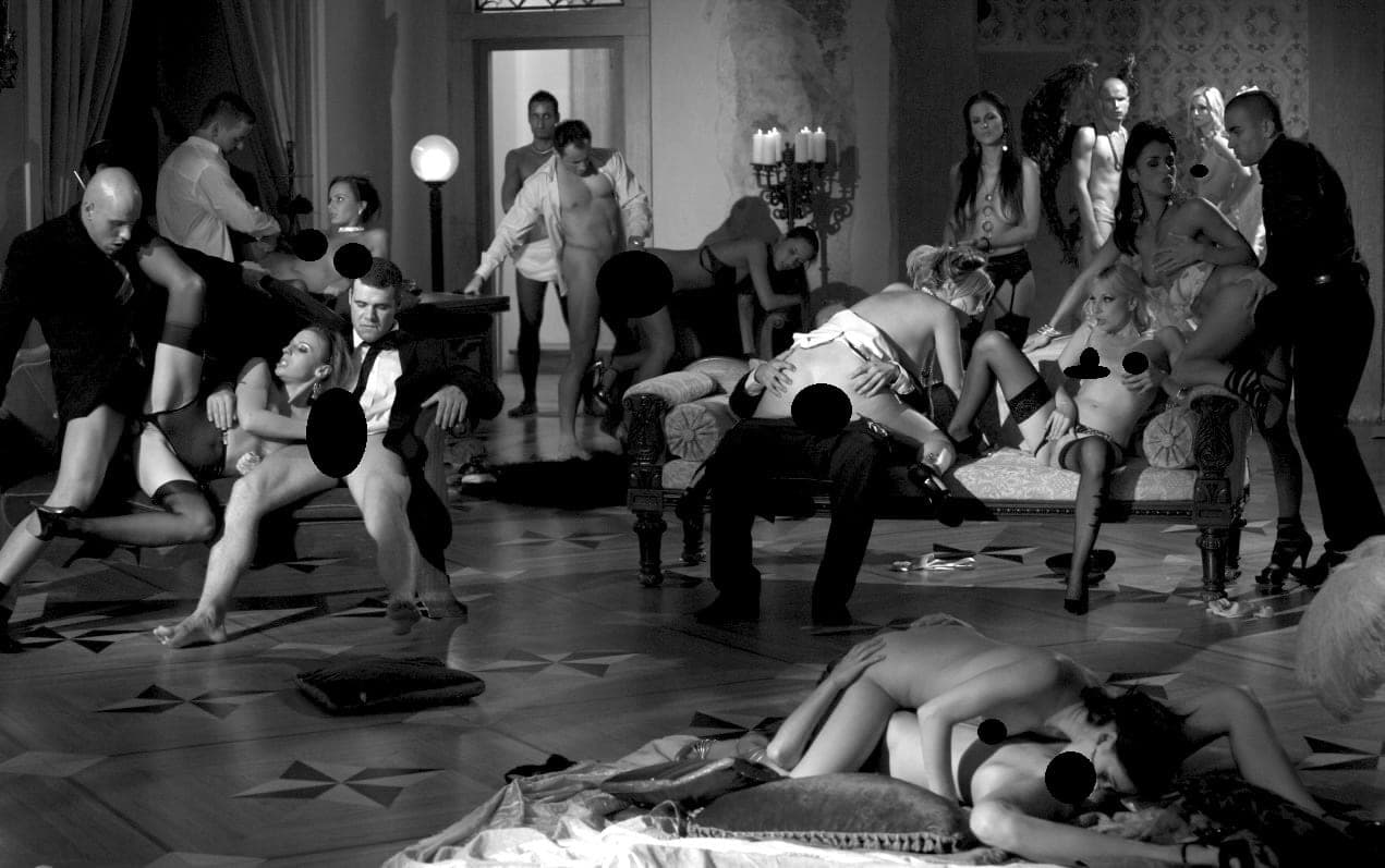 Black-and-white staged party scene in an ornate hall with many adults in various poses, explicit areas covered by black dots