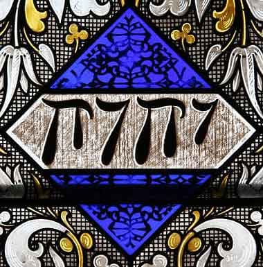 Stained glass window panel showing the Hebrew Tetragrammaton inscribed on a blue diamond with gold scrollwork